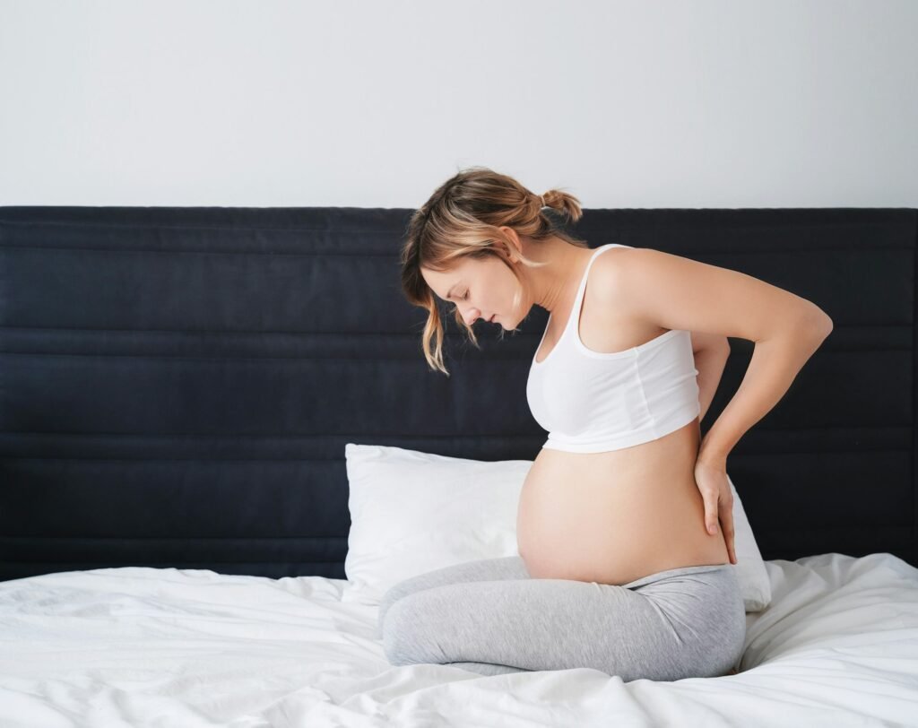 Pregnant woman suffering lower back pain, feeling unwell or sick.