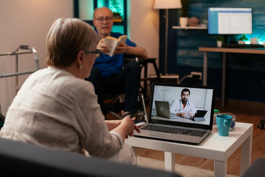 paciente da terceira idade realizado consulta médica através de videoconferência utilizando um computador.